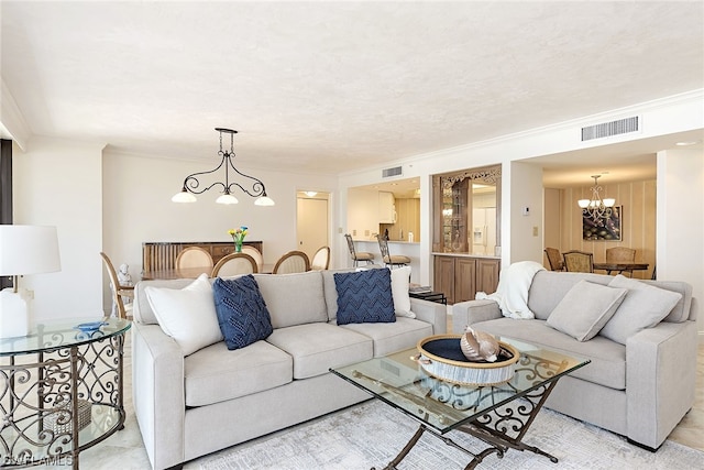 living room featuring crown molding and a chandelier