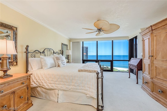 carpeted bedroom with access to exterior, ceiling fan, a wall of windows, a water view, and crown molding