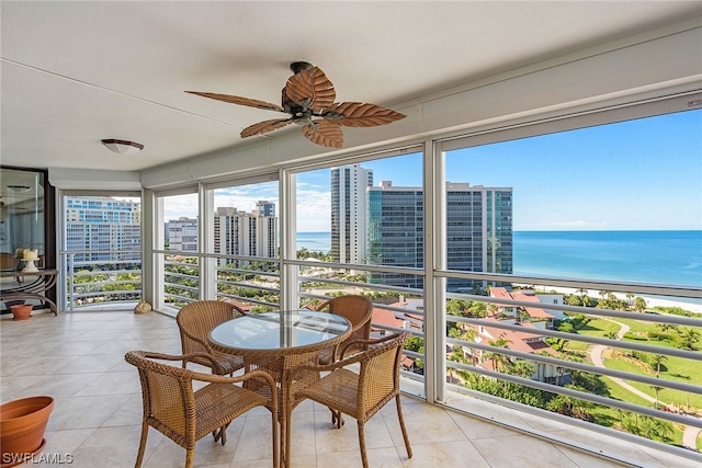 sunroom / solarium featuring a water view and ceiling fan