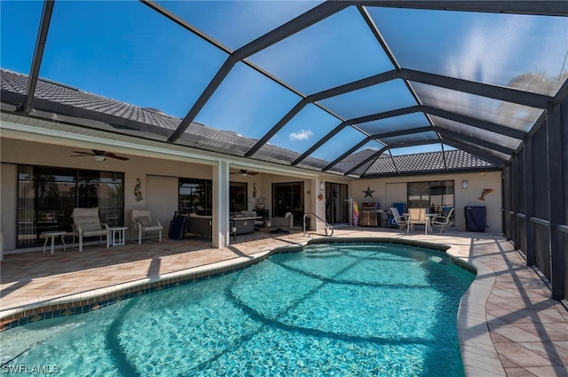 view of swimming pool with a patio area, ceiling fan, and a lanai