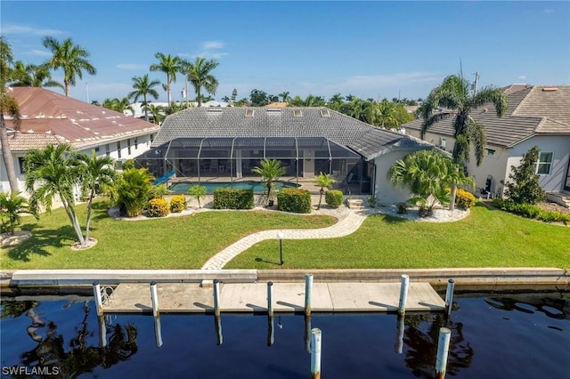 rear view of property with a lanai, a yard, and a water view