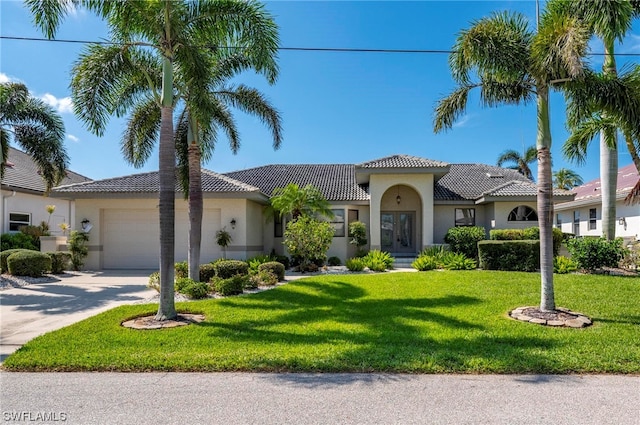 mediterranean / spanish-style house with a garage and a front lawn