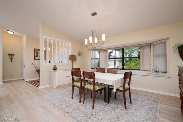 dining room featuring a notable chandelier, vaulted ceiling, and light hardwood / wood-style flooring