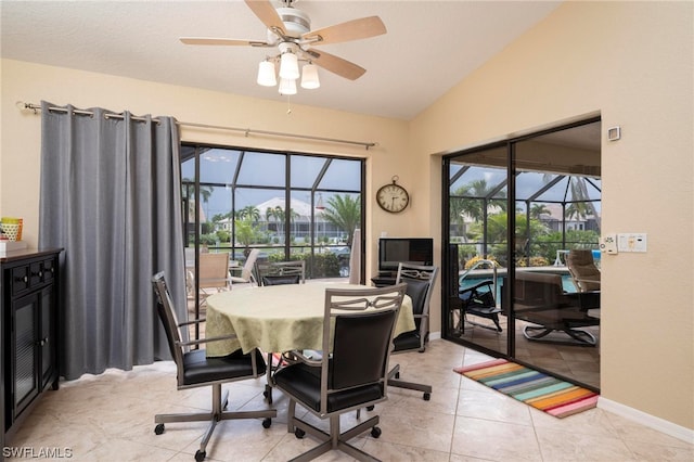 dining area with ceiling fan, light tile patterned flooring, and vaulted ceiling