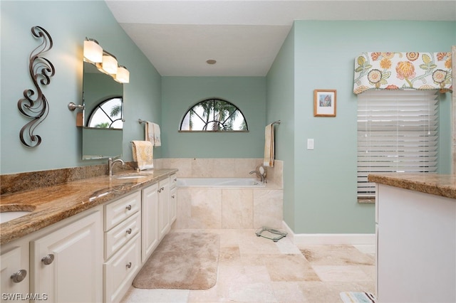 bathroom with vanity and tiled tub