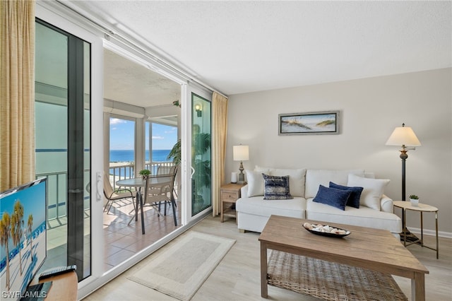 7000 Estero Blvd Unit 403, Fort Myers Beach, FL 33931 - living area with a water view, light wood-style floors, and a textured ceiling