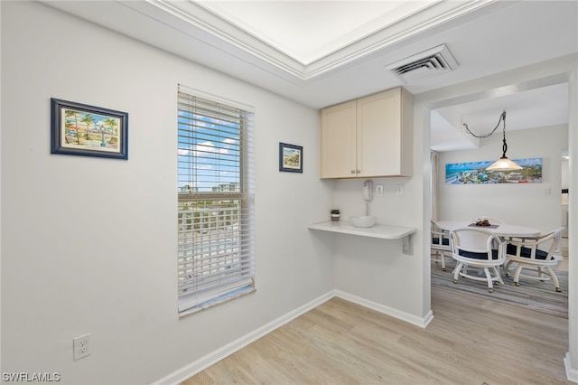 7000 Estero Blvd Unit 403, Fort Myers Beach, FL 33931 - kitchen with light wood-style flooring, baseboards, cream cabinets, light countertops, and pendant lighting