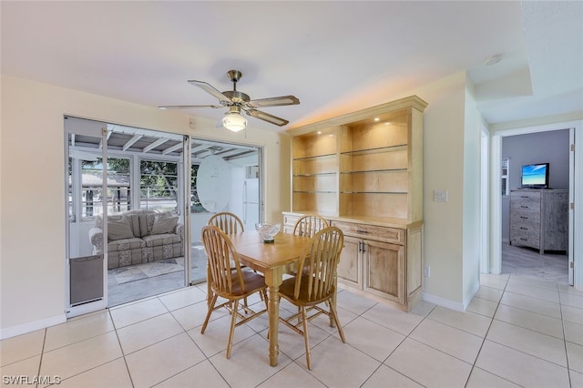 tiled dining room with built in shelves and ceiling fan