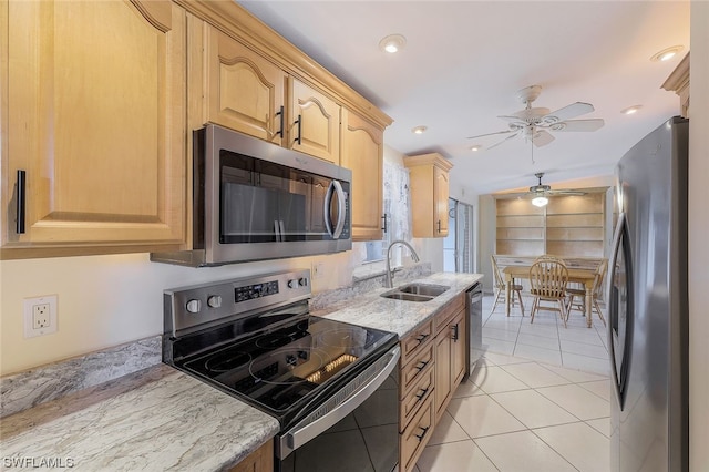 kitchen with sink, ceiling fan, light tile patterned floors, appliances with stainless steel finishes, and light stone counters