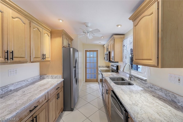 kitchen with light stone countertops, stainless steel appliances, a healthy amount of sunlight, and sink