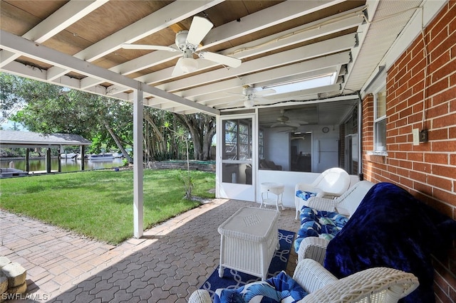 view of patio featuring a water view and a sunroom