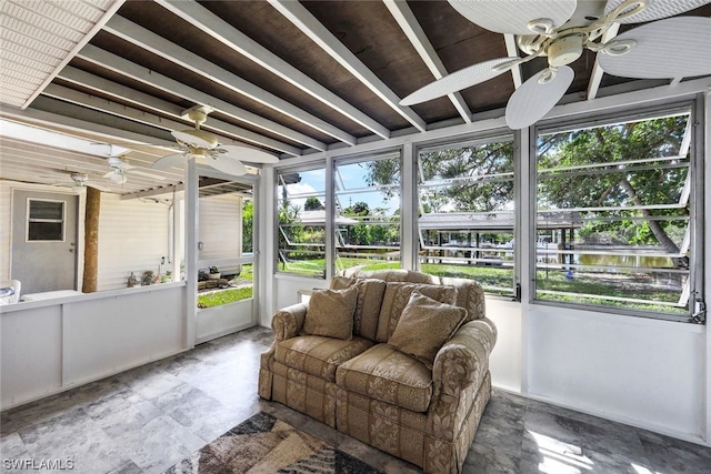 sunroom with ceiling fan and a water view