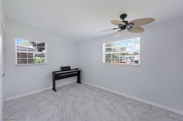 spare room featuring plenty of natural light and ceiling fan