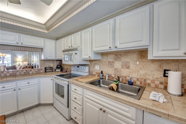 kitchen featuring tasteful backsplash, white appliances, and white cabinetry