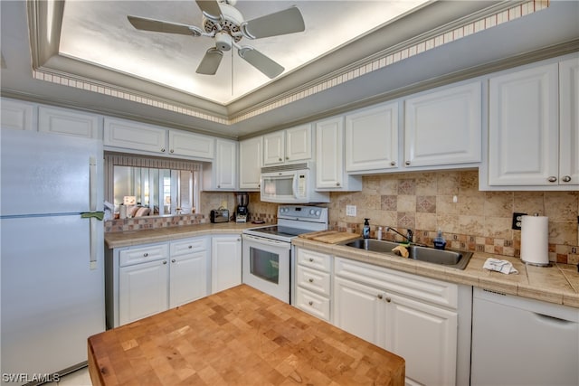 kitchen with white appliances, ceiling fan, sink, tasteful backsplash, and white cabinetry