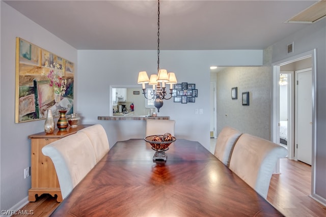 dining room featuring an inviting chandelier and wood-type flooring