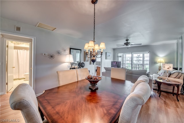 dining area featuring ceiling fan with notable chandelier and light wood-type flooring