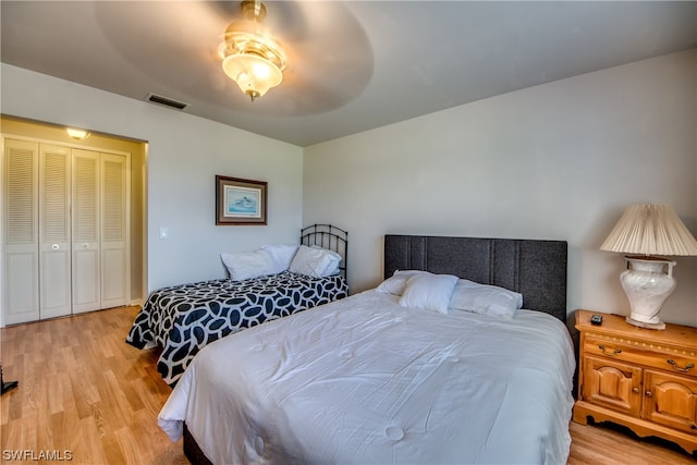 bedroom with a closet, ceiling fan, and light wood-type flooring