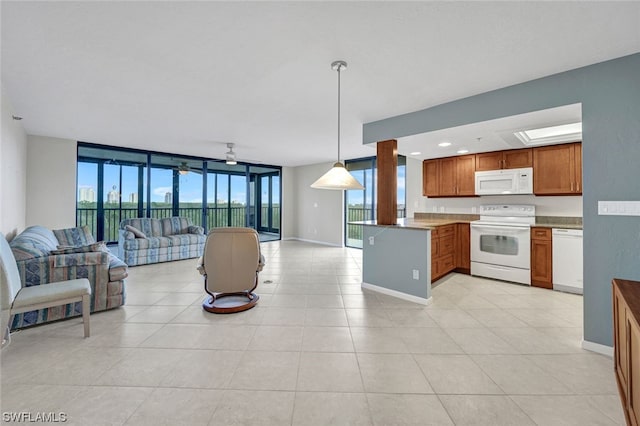 kitchen with kitchen peninsula, expansive windows, white appliances, ceiling fan, and hanging light fixtures