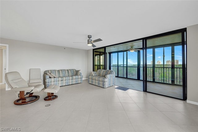 tiled living room featuring ceiling fan and a wall of windows