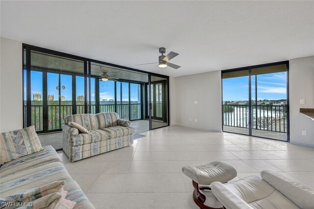 26235 Hickory Blvd Unit 4B, Bonita Springs, FL 34134 - living room featuring a wall of windows, ceiling fan, plenty of natural light, tile patterned flooring, and baseboards