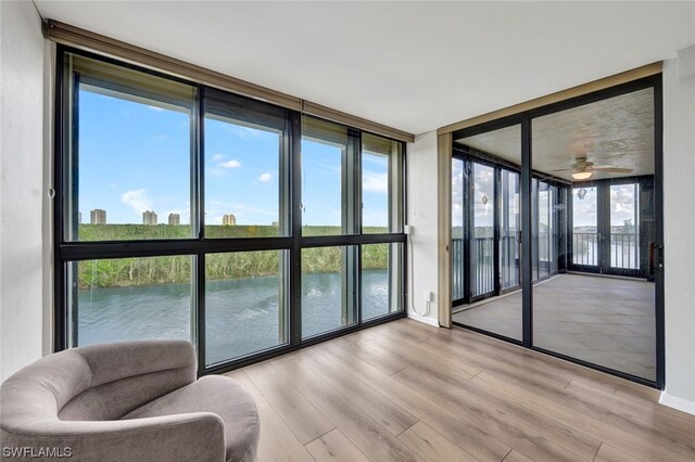 26235 Hickory Blvd Unit 4B, Bonita Springs, FL 34134 - sunroom / solarium with a wall of windows, wood finished floors, a water view, and baseboards