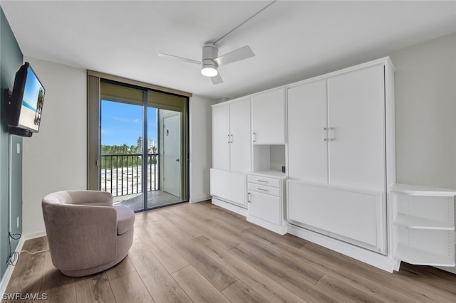 sitting room with floor to ceiling windows, light hardwood / wood-style floors, and ceiling fan