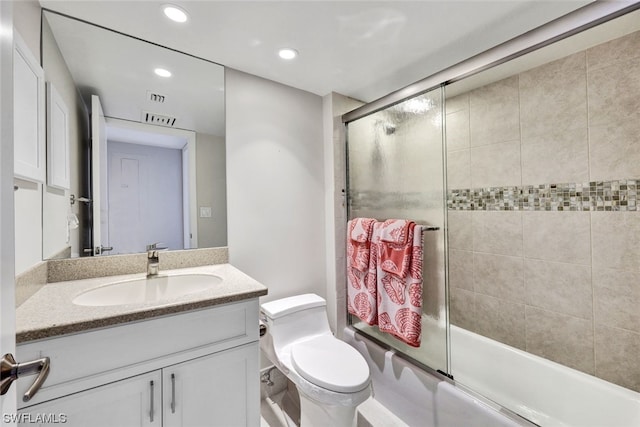 full bathroom with vanity, combined bath / shower with glass door, and toilet