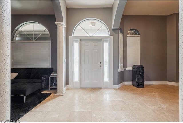 tiled entryway with a healthy amount of sunlight and decorative columns