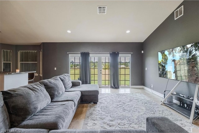 living room featuring vaulted ceiling and french doors