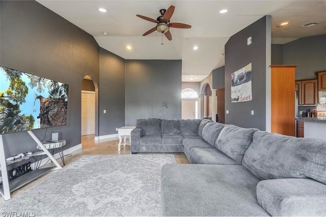 living room with a high ceiling and ceiling fan