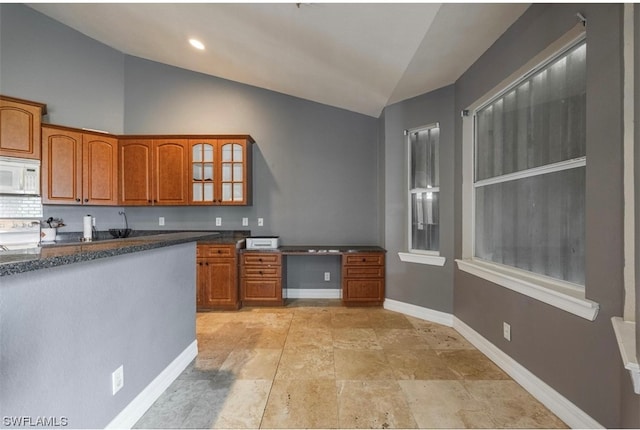 kitchen with lofted ceiling, backsplash, and light tile floors