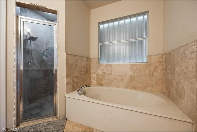 bathroom featuring shower with separate bathtub and tile flooring