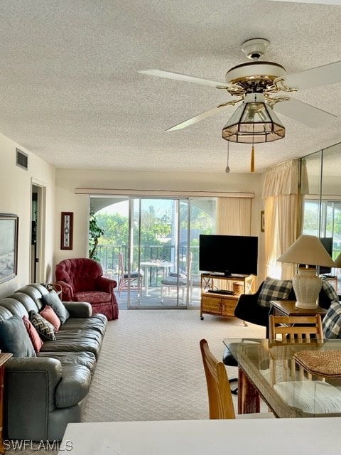 living room featuring a textured ceiling, carpet, a wealth of natural light, and ceiling fan