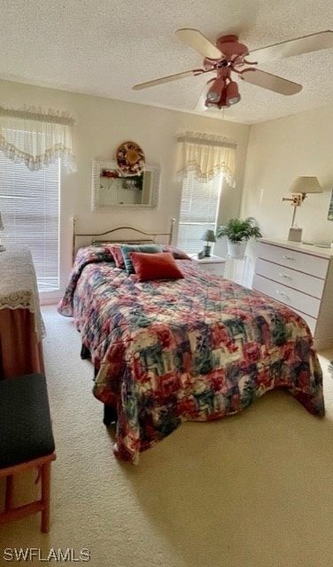 carpeted bedroom featuring a textured ceiling and ceiling fan