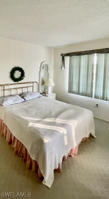 bedroom with a textured ceiling and carpet flooring