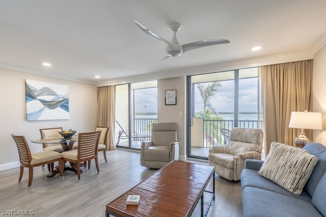 living room featuring ceiling fan, light hardwood / wood-style flooring, and crown molding