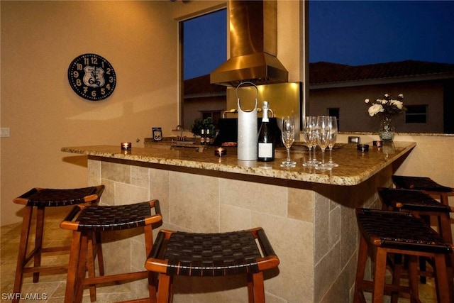 bar with a sink, a bar, and island range hood