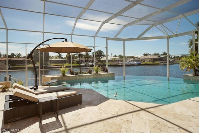 outdoor pool with a water view, glass enclosure, and a patio