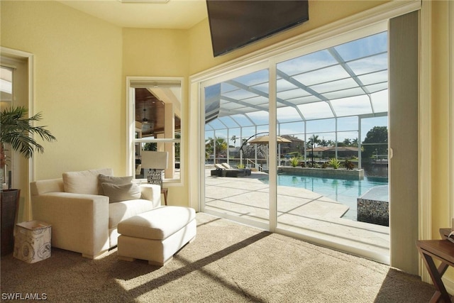 doorway to outside with a healthy amount of sunlight, a sunroom, and carpet flooring