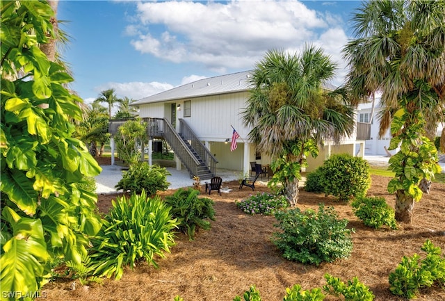 rear view of house featuring a patio area, stairway, and a deck