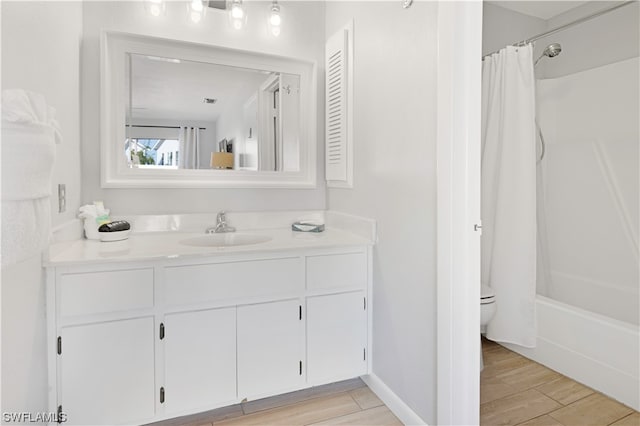 full bathroom with hardwood / wood-style floors, toilet, shower / tub combo, and vanity