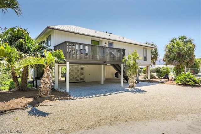 rear view of property featuring a carport and driveway