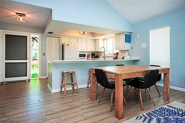 14865 Mango Ct, Captiva, FL 33924 - dining room with vaulted ceiling, light wood-style floors, and baseboards