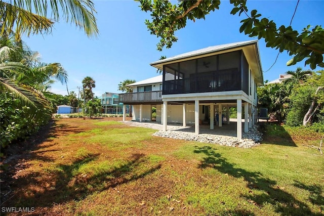 14865 Mango Ct, Captiva, FL 33924 - rear view of property featuring a yard, a patio area, and a sunroom