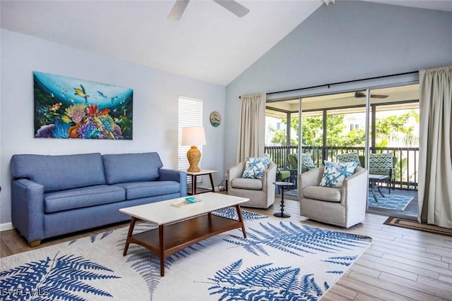 living room with a wealth of natural light, high vaulted ceiling, ceiling fan, and wood finished floors