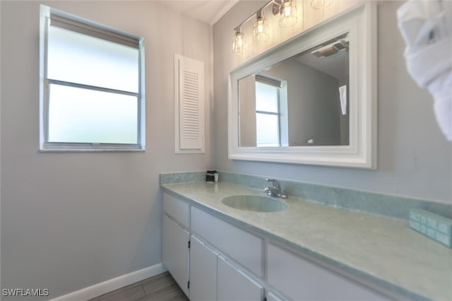 bathroom featuring visible vents, baseboards, and vanity