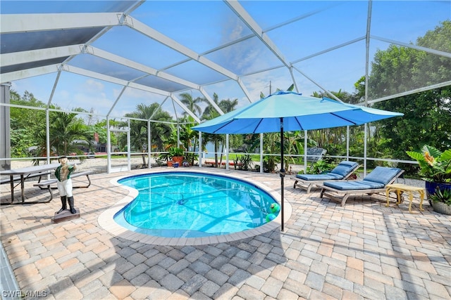 view of swimming pool featuring glass enclosure and a patio