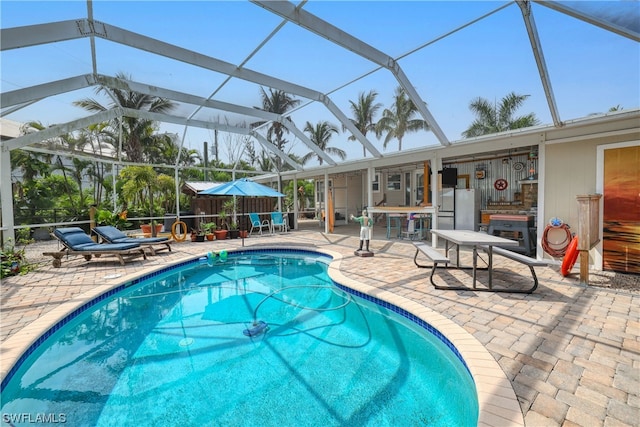 view of swimming pool featuring a patio and glass enclosure