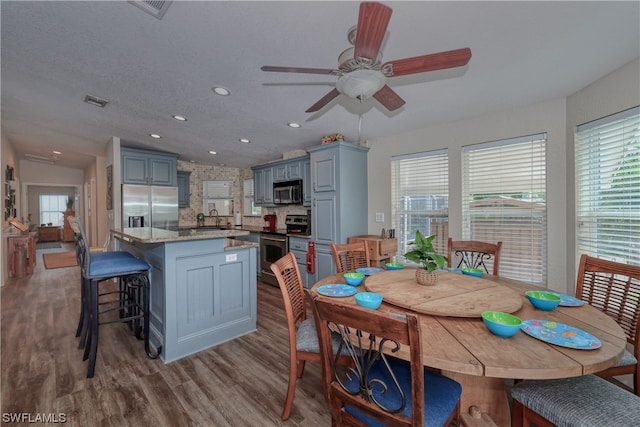 dining space featuring ceiling fan, a textured ceiling, lofted ceiling, dark hardwood / wood-style floors, and sink